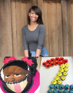 Young woman standing against wall smiling with picture of a cake shaped like girl face and picture of a number two made out of cupcakes that look like Seasame Street characters.
