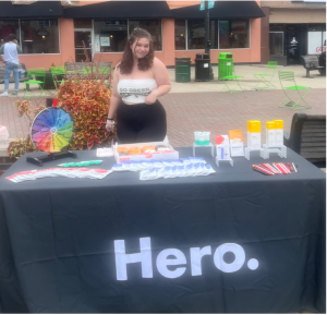 A portrait of person standing at a brand ambassador desk for Hero Cosmetics.