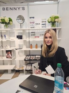 A person poses in front of an eyewear brand