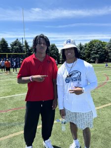 Two people stop for a smiling pose on a football field