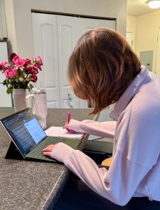 A person works on a laptop at a desk