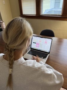 a woman works at a laptop computer
