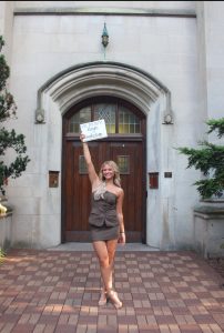 A woman poses in front of a door