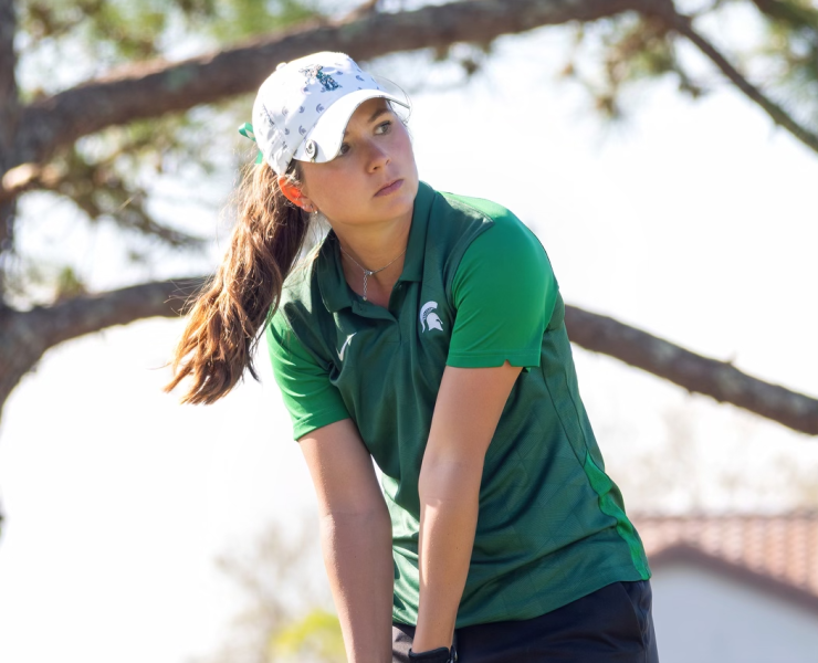 A golfer focuses before putting.