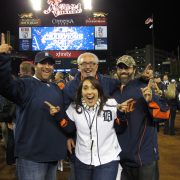 People smile while posing outside at Comerica Park in Detroit, Michigan.
