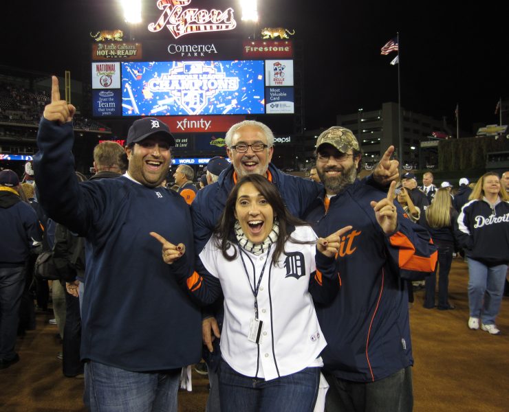 People smile while posing outside at Comerica Park in Detroit, Michigan.
