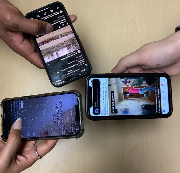 a closeup photograph of three hands holding smart phones; the screens all show social media platforms