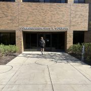 Exterior photograph of a student walking into a building.