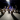 A group of people solemnly look at an art exhibit in a dimly lit room