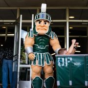 MSU mascot Sparty pushing a cart.
