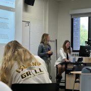 A faculty member speaks to a group of students