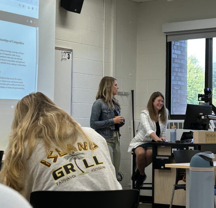 A faculty member speaks to a group of students