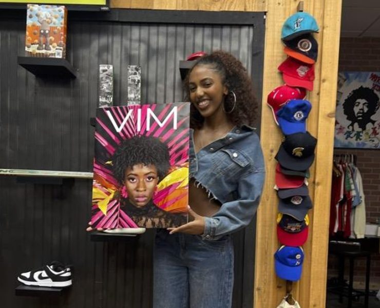 Portrait of a smiling student holding a poster