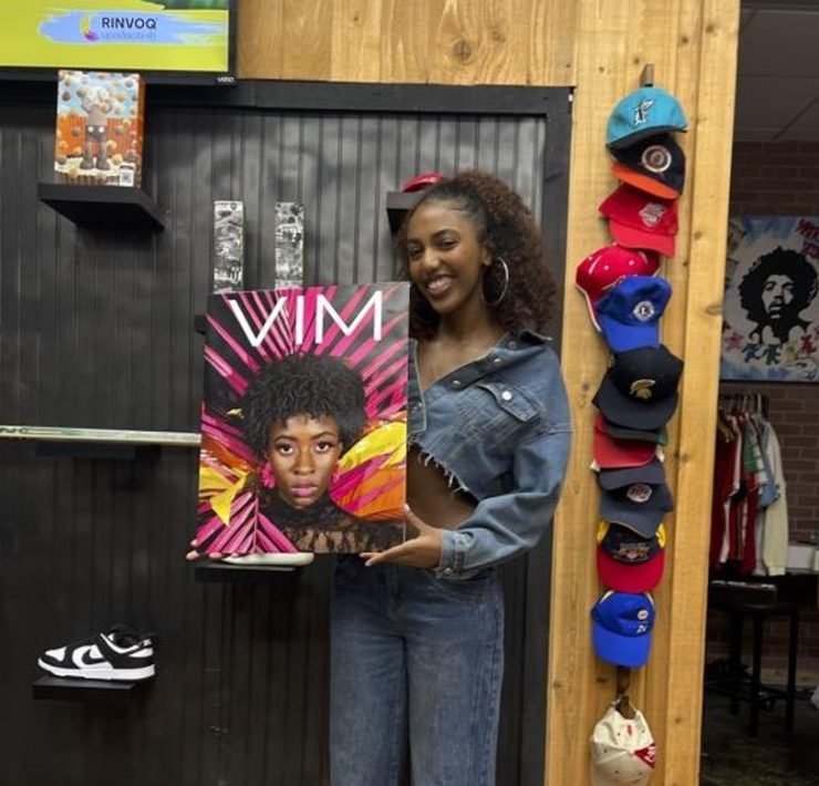 Portrait of a smiling student holding a poster