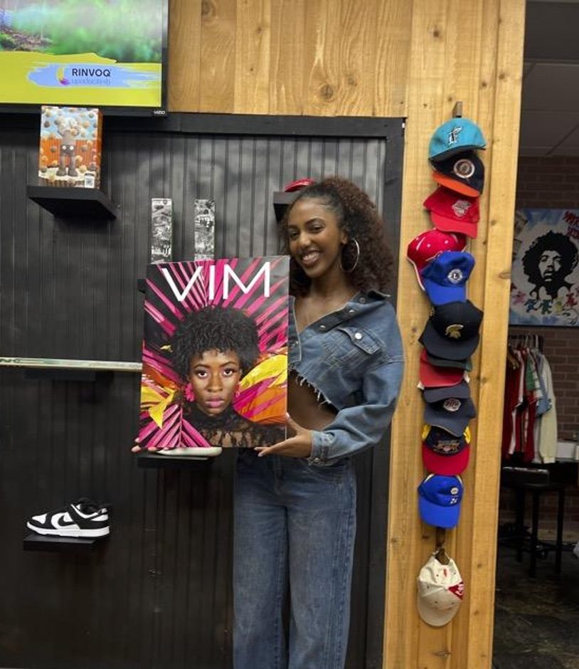 Portrait of a smiling student holding a poster