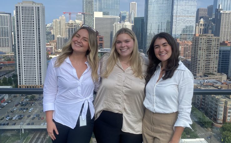 Three people pose for a photograph