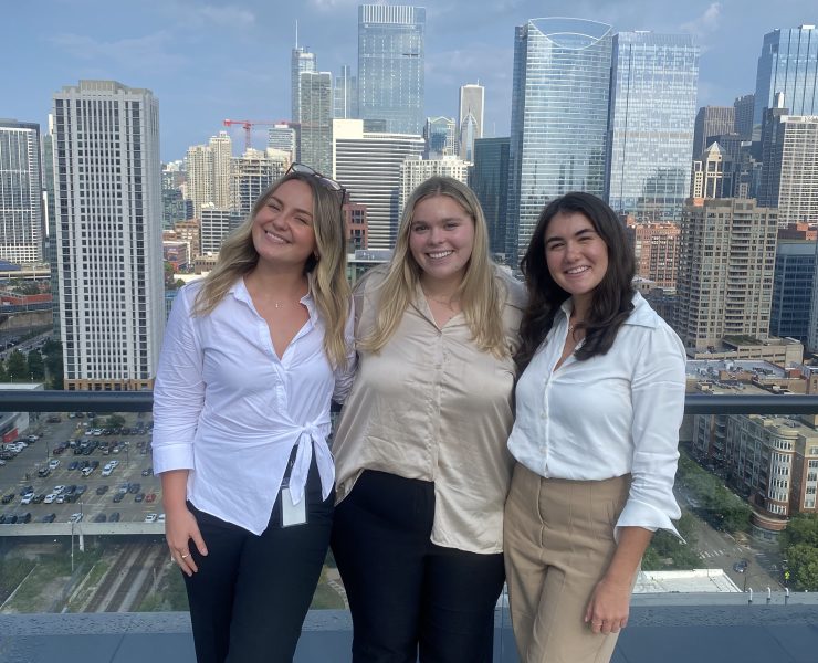 Three people pose for a photograph