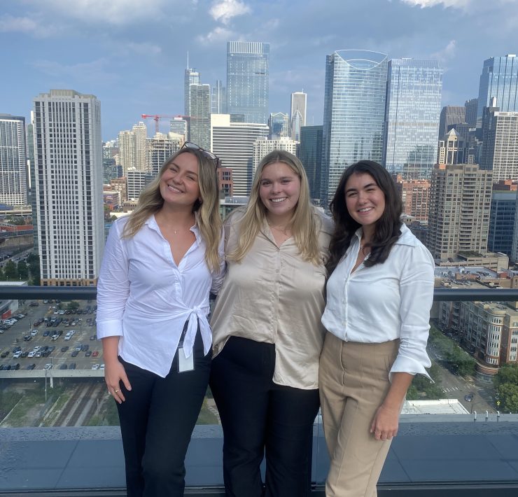 Three people pose for a photograph