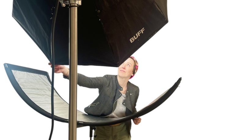 A person adjusts lighting in a photo studio.