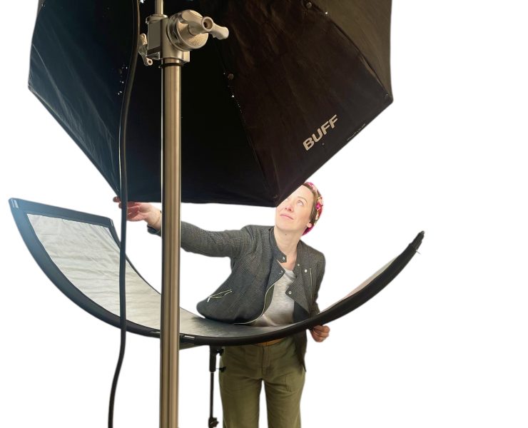 A person adjusts lighting in a photo studio.