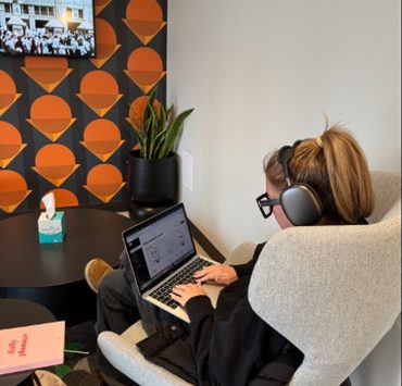 A person working at a laptop with headphones