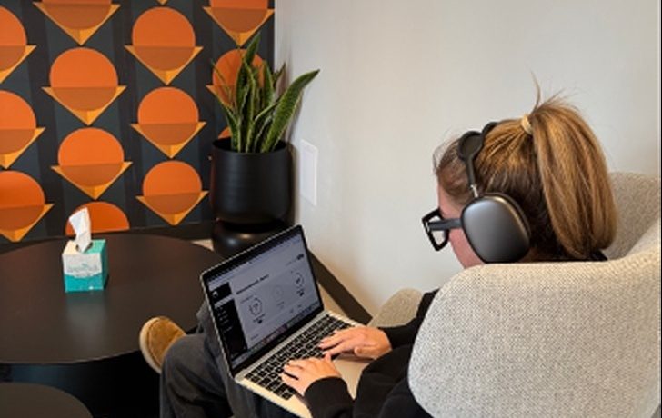 A person working at a laptop with headphones