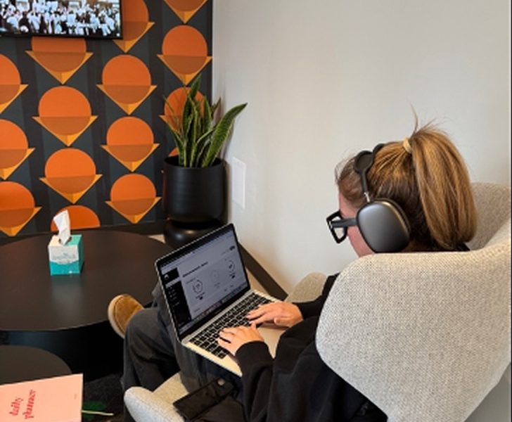 A person working at a laptop with headphones