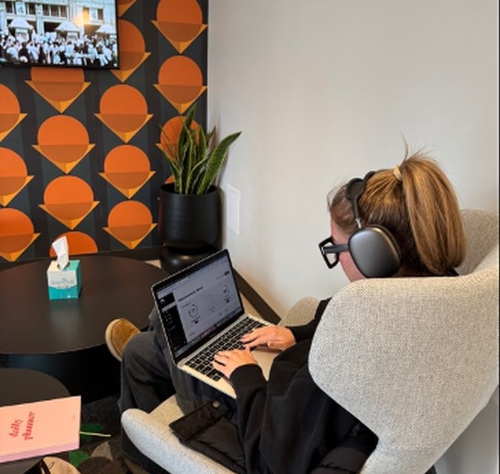 A person working at a laptop with headphones