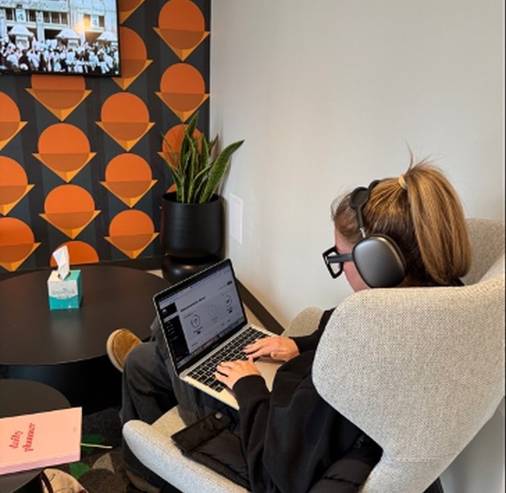 A person working at a laptop with headphones