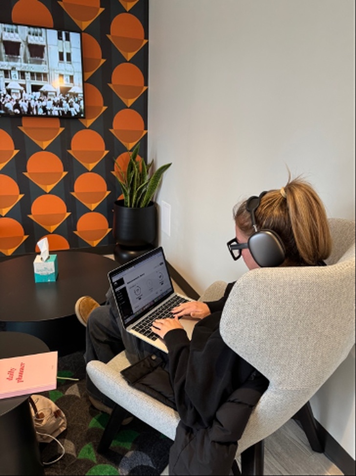 A person working at a laptop with headphones