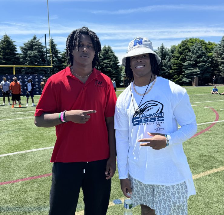 Two people stop for a smiling pose on a football field