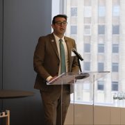 a man in a suit presents at a modern podium