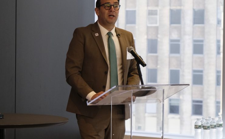 a man in a suit presents at a modern podium