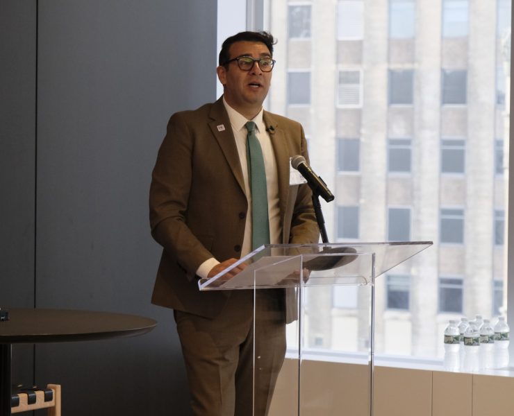a man in a suit presents at a modern podium