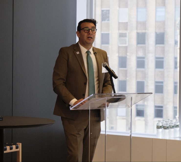a man in a suit presents at a modern podium