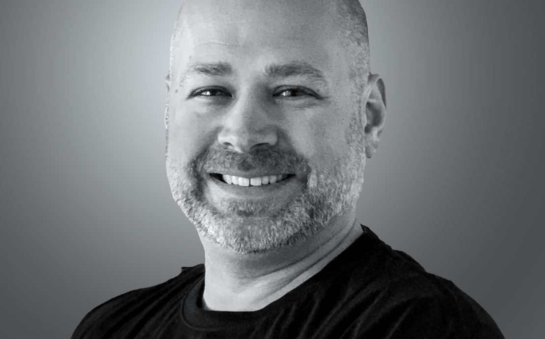 A person smiling on a gray background