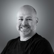 A person smiling on a gray background