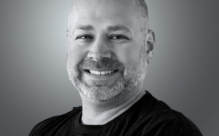 A person smiling on a gray background