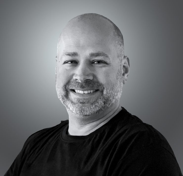 A person smiling on a gray background