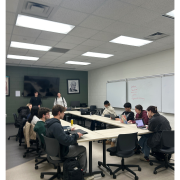 A group of people work hard at a table.