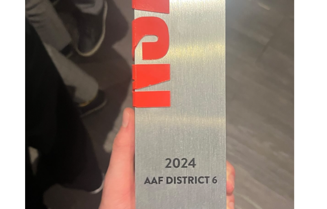 An physical award is held in the hand of a winner from MSU