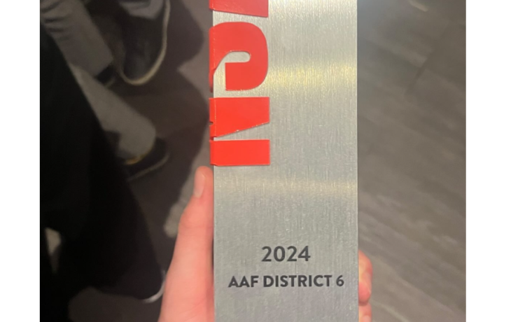 An physical award is held in the hand of a winner from MSU