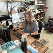 A person happily works on a computer at a desk in a room