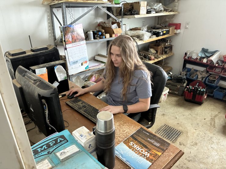 A person happily works on a computer at a desk in a room
