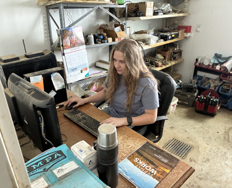 A person happily works on a computer at a desk in a room
