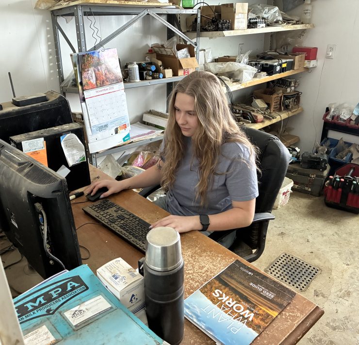 A person happily works on a computer at a desk in a room