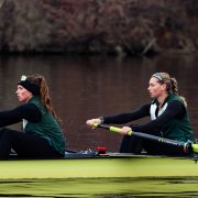Two woman row a boat in the river