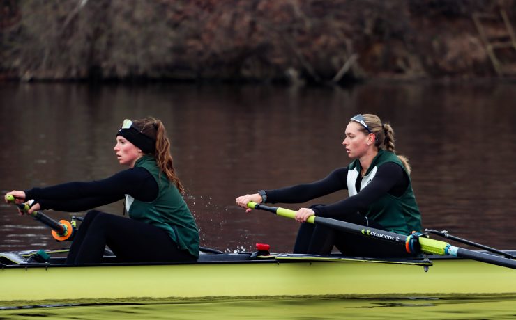 Two woman row a boat in the river