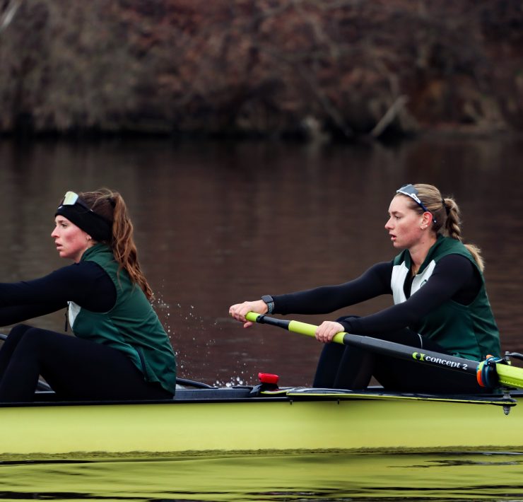 Two woman row a boat in the river