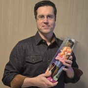 A person holding a doll that has a hearing aid